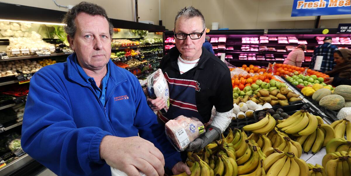 left in the dark: Urana Road grocery store owner Craig English and butcher Mark Bolinghaus were caught by surprise when a power outage happened on Wednesday morning. Picture: JOHN RUSSELL