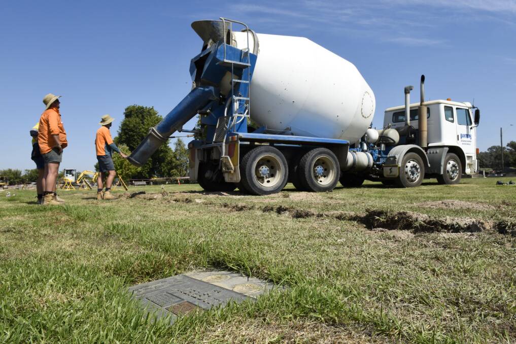 Channeling change: Concrete is poured over a pipe designed to improve drainage in a flood-prone area of Albury's Waugh Road cemetery near its border with James Fallon High School. Picture: SIMON BAYLISS