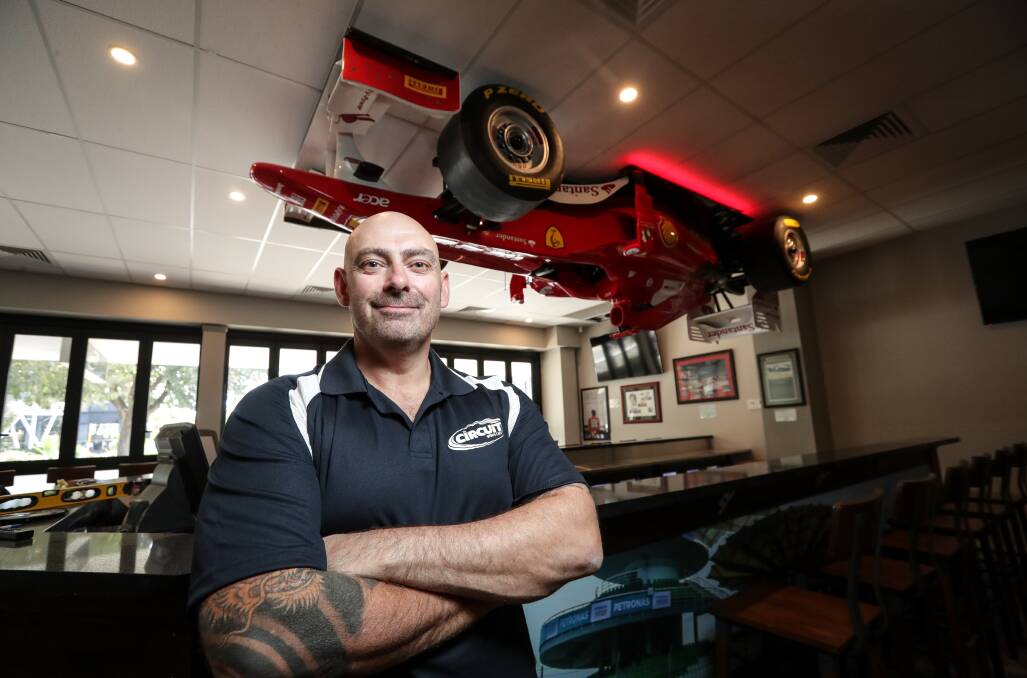 Will you look at that: Anthony Clark with a replica Formula One car which hangs above the bar at new Circuit Sports Cafe in Albury. Picture: JAMES WILTSHIRE