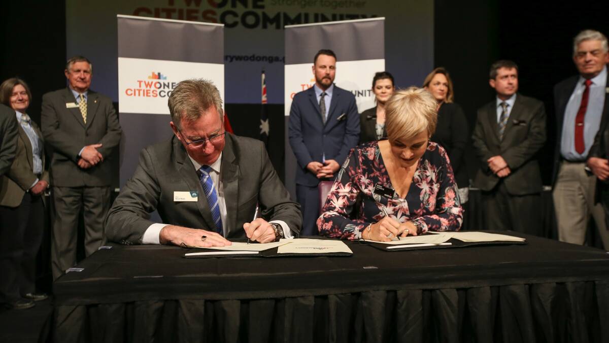 We do: Mayors Kevin Mack and Anna Speedie sign the Two Cities One Community Partnership Agreement. Picture: JAMES WILTSHIRE
