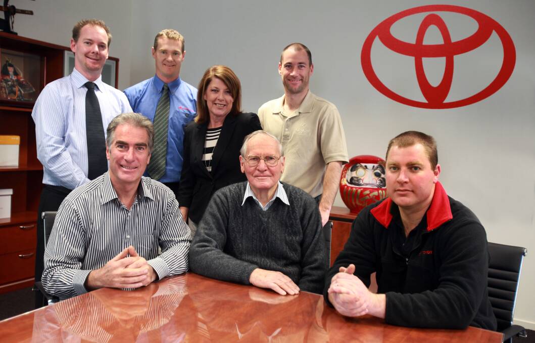 Dealer principal: Lionel Jacob, sitting between son Neville and grandson Adam and with other Jacob Toyota staff in 2011, has been remembered as a brilliant businessman. 