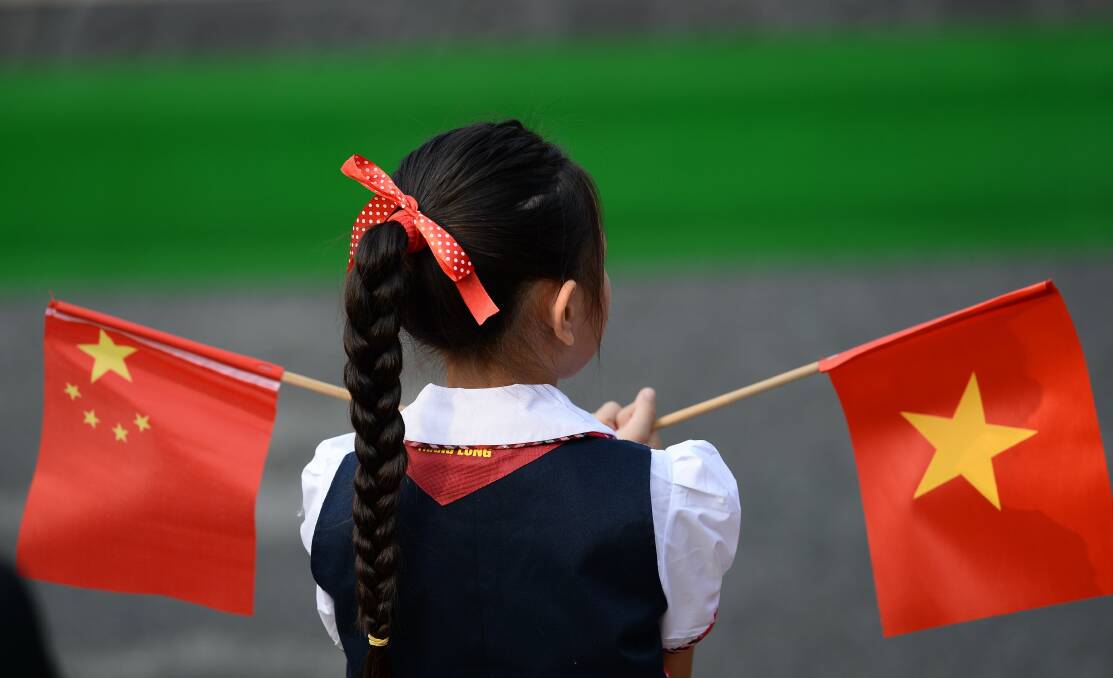 Star-filled symbols: A girl holds the flags of China and Vietnam, the countries that Wodonga mayor Anna Speedie would have travelled to on an education trip. 