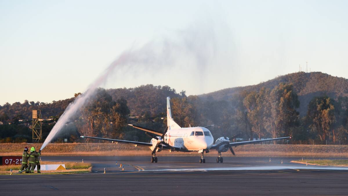 Copping a spray: Firefighters salute Barry Anderson's 20 years of flying with Regional Express and its predecessor with a water salute at Albury airport on Friday night. Picture: MARK JESSER 