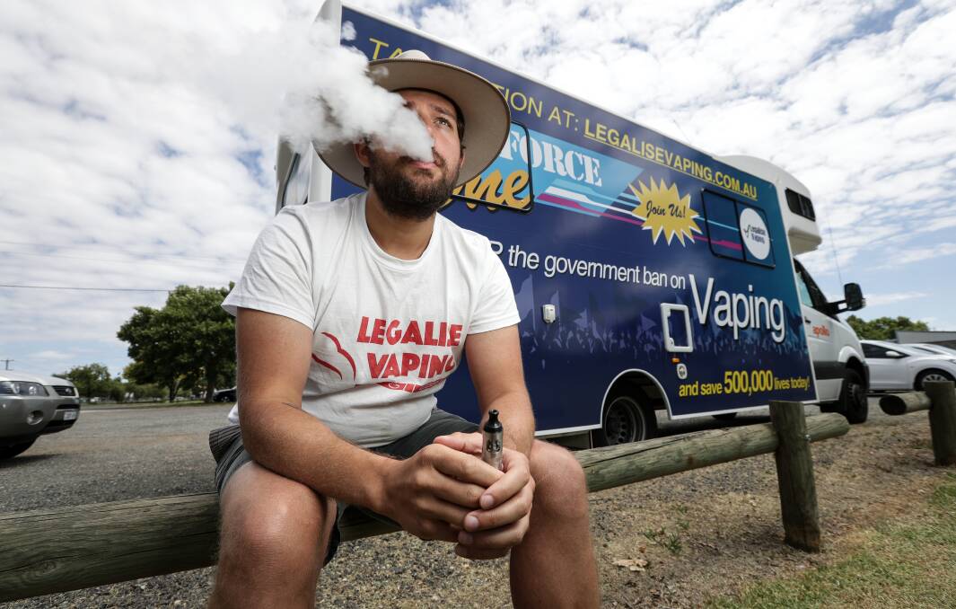 A head of steam: Brian Marlow vapes in front of a campaign van pushing for the legalisation of the use nicotine in e-cigarettes. The vehicle stopped in South Albury as part of a national tour. Picture: JAMES WILTSHIRE