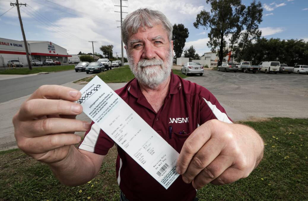 Not happy: Wodonga Swtichboard Manufacturers owner Peter Russell with one of the infringement notices put on his workers' vehicles by a council parking inspector. Picture: JAMES WILTSHIRE 