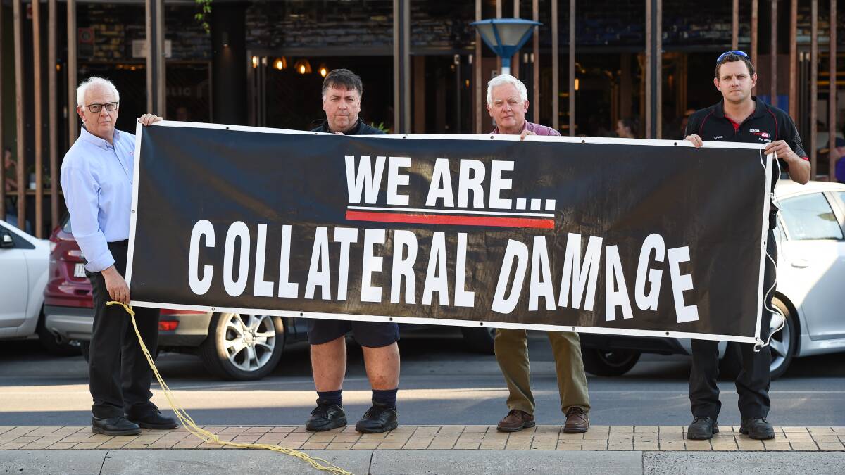 Very concerned: Supermarket operators Bob Mathews (East Albury, Springdale Heights), Gary Evans (Norris Park) and father and son Brian and Craig Waldron (Corowa) with their protest banner. Picture: MARK JESSER