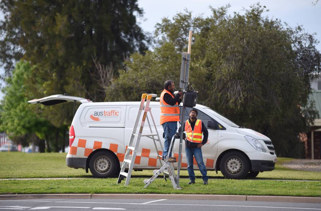 On the job: Contractors with one of the cameras which was installed at the intersection of Moorefield Park Drive and Melbourne Road in Wodonga as part of VicRoads data collection.