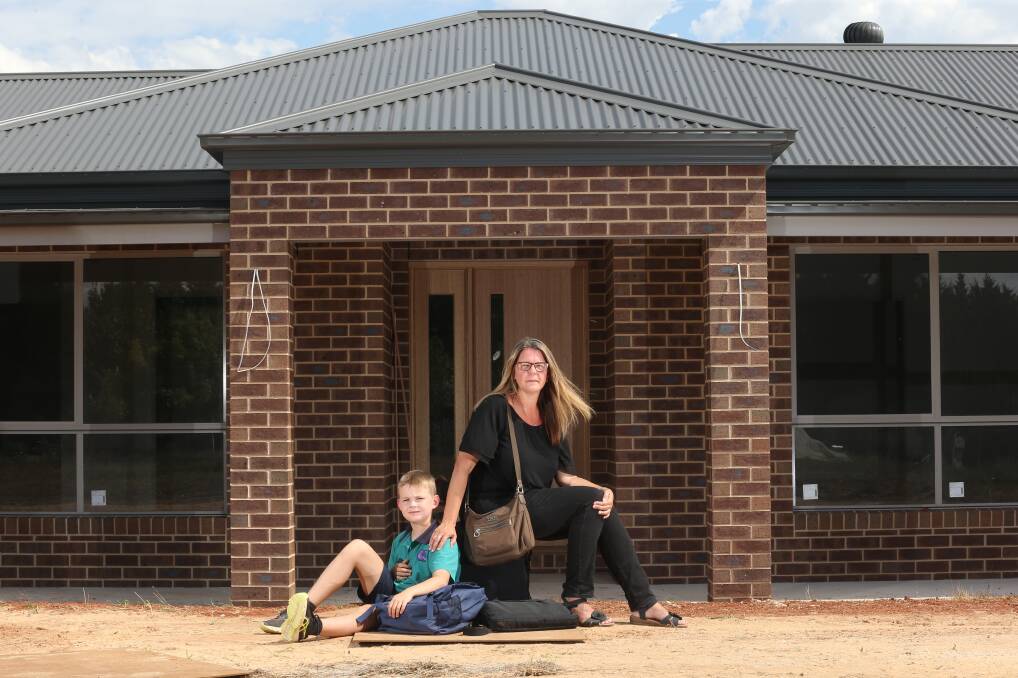 Left waiting: Robyn King and her son Mitchell, 9, at their new Osbornes Flat house which has not been connected to the power grid because of an industrial dispute.