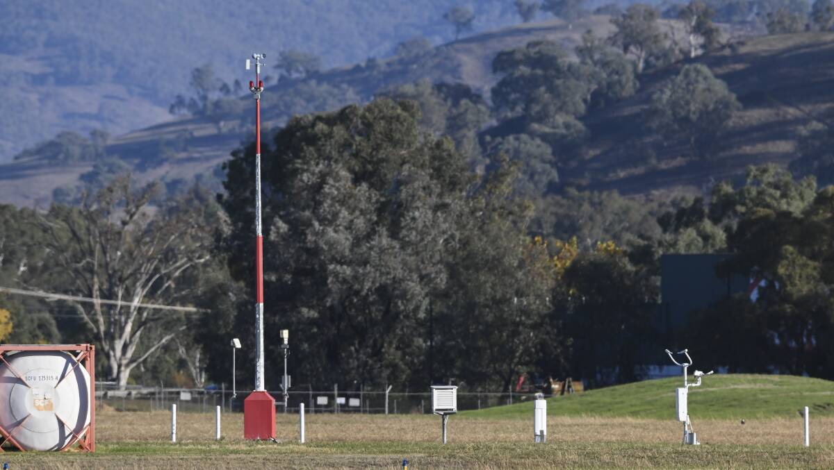The automated weather station at Albury airport looking west. It includes an anemometer marked by its red and silver post, and a white box, known as a Stevenson screen which contains measuring instruments. Picture by Mark Jesser