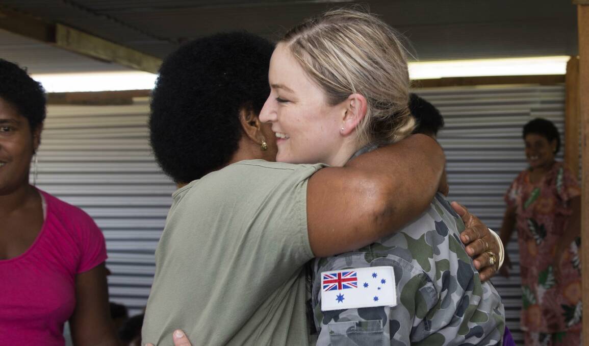 Thank you hug: A Fijian aid beneficiary hugs Albury-raised sailor Katie Clohesy who helped Cyclone Winston recovery efforts. Picture: DEFENCE DEPARTMENT