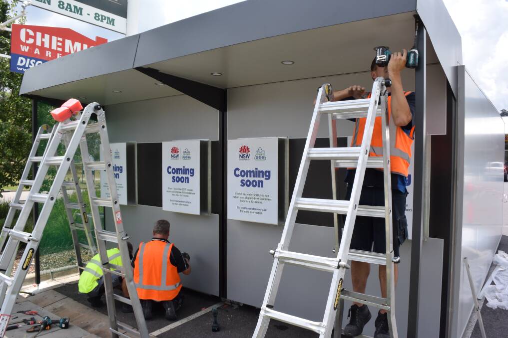 New technology: Contractors install a reverse vending machine in the car park of the Springdale Heights shopping centre to cater for drink containers being returned for 10-cent deposits from December 1.
