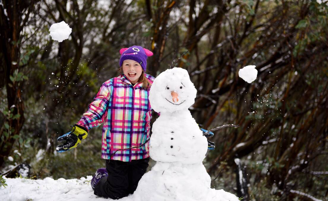 Ella Phoebe 9, took to building a snowman at Falls Creek with the resort blanketed in snow on Sunday. Picture: CHRIS HOCKING