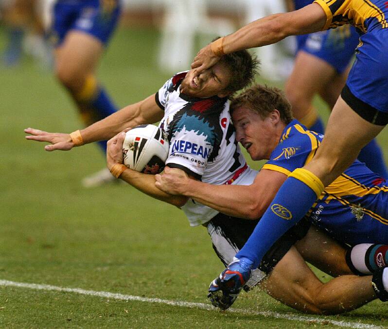 Brett Finch (centre) tackles Penrith's Jarrod Sammut while playing for Penrith in a pre-season trial at the Lavington Sportsground in 2008.