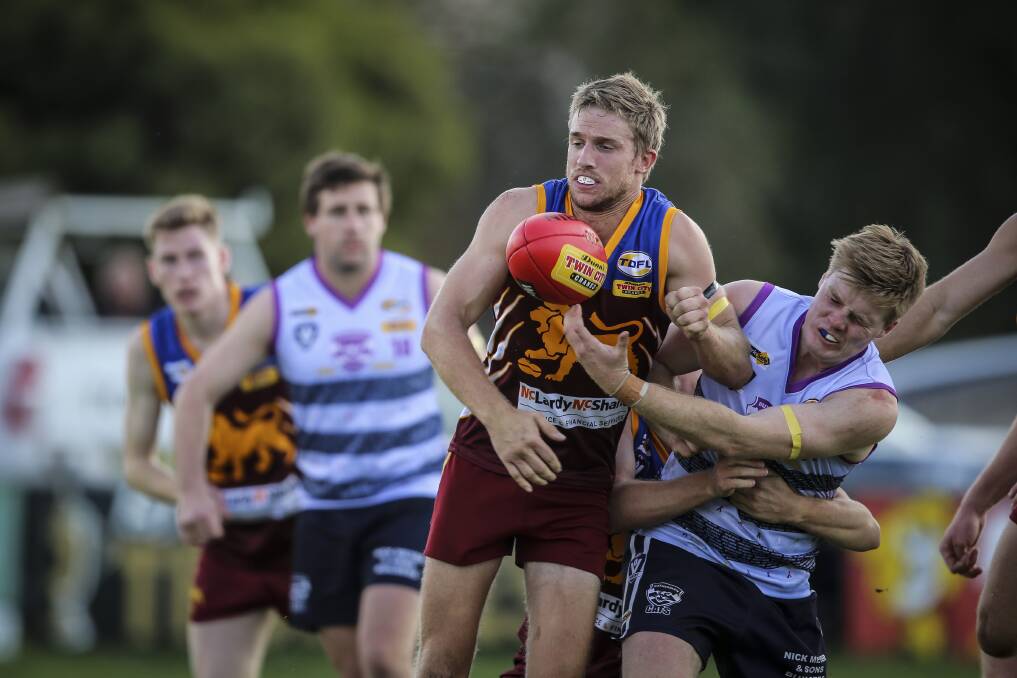 FIERCE CONTEST: Wahgunyah's Rhys Carlisle (centre) tries to keep possession away from Rutherglen's Josh Quick in the pulsating clash between the strong rivals.