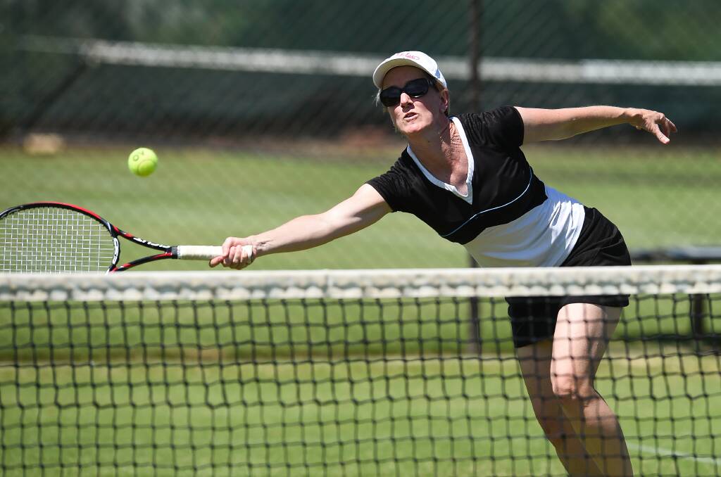 FULL STRETCH: Helen Curtis reaches for a forehand volley during the ladies competition yesterday. Picture: MARK JESSER