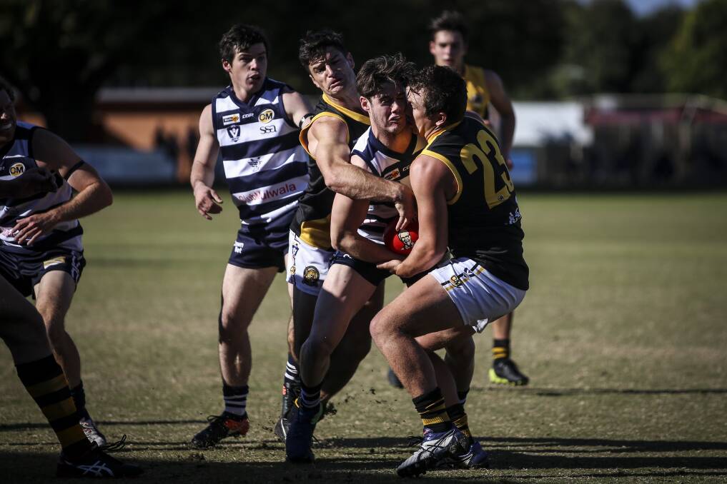 Logan Morey (centre) broke his arm at the five-minute mark against Myrtleford and played out the game.