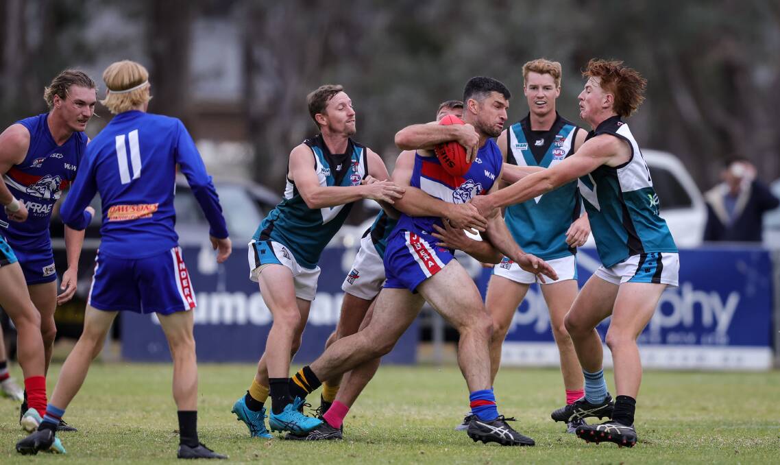 Bulldogs coach Joel Mackie tries to barge his way through a pack of Power players at Jindera on Saturday. Picture by James Wiltshire