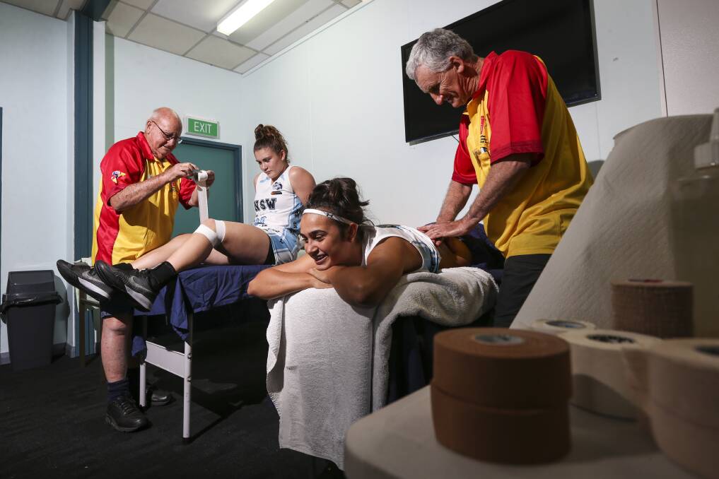 HARD WORK: Bendigo Sports Trainers Association stalwarts John Murnane and John Vanston helping out NSW stars Piper Duck and Serena Waters. Picture: JAMES WILTSHIRE