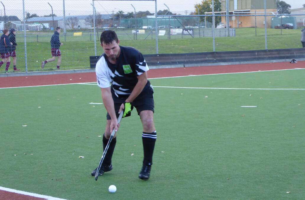 KEEPING CONTROL: A very watchful Darryl Lavis maintains possession for Magpies in challenging conditions at Albury Hockey Centre on Sunday. 