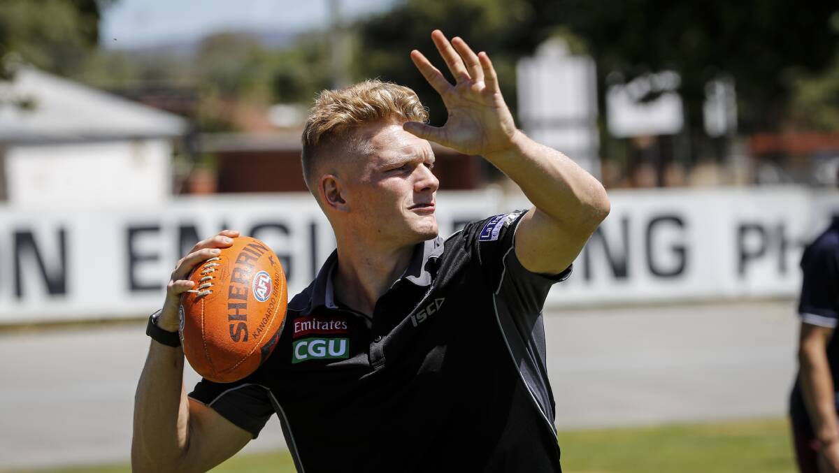 GO LONG: Adam Treloar tested his throwing skills during a football clinic with Wangaratta school students at Norm Minns Oval on Tuesday afternoon. Picture: JAMES WILTSHIRE