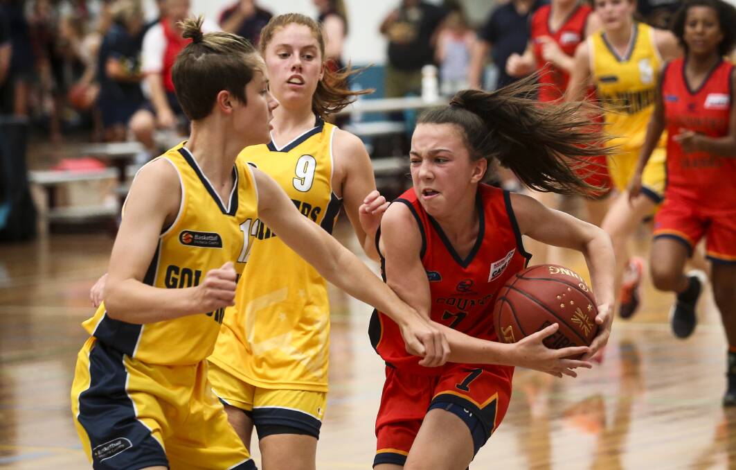 DETERMINED: South Australia's Emily Close protects the ball from Victoria's Annabel Strahan at the Australian Country Junior Basketball Cup. Pictures: JAMES WILTSHIRE