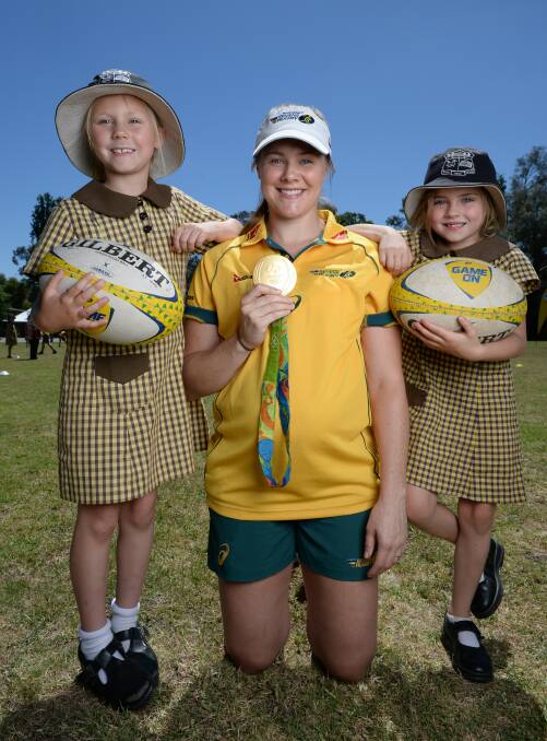 GREAT DAY: Australian women's rugby sevens Olympic gold medallist Nicole Beck during her visit to Lavington Public School this week. She is pictured with year one students Regan Walkerden, 7, and Mia Watts, 6. Picture: MARK JESSER