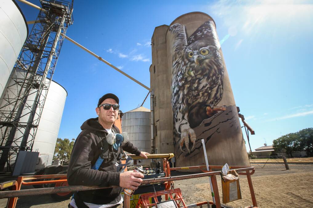 Jimmy Beattie (Dvate) painting a barking owl on a silo at Goorambat as part of Wall to Wall in 2018. Picture by James Wiltshire