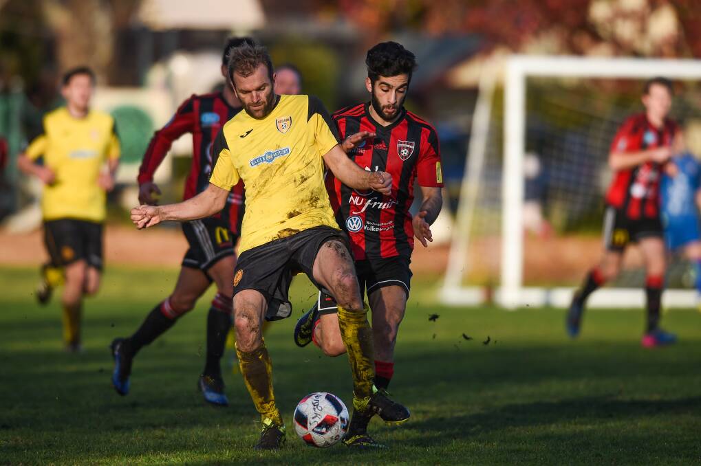 IN CONTENTION: Albury Hotspurs' Paul Kinning and Wangaratta's George Elkotta fight for the ball earlier this season. Hotspurs are one of three teams in the hunt for the last spot in the finals.