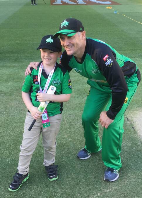 UNFORGETTABLE: Wodonga's Elijah Delemontex with Melbourne Stars captain David Hussey after tossing the coin at the MCG on Saturday night. Elijah was allowed to keep the coin and also got his bat signed by Hussey.