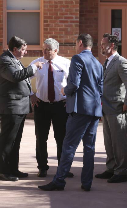 Negotiations: Crown prosecutor Max Perry in discussions with lawyers outside court at Wangaratta where accused drug dealers appeared on Thursday. 