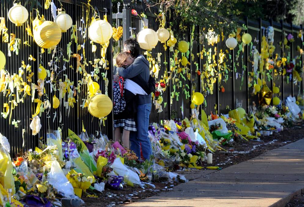 TRIBUTES: A wall of flowers and yellow tributes outside Leeton High School after the death of much-loved teacher Stephanie Scott.