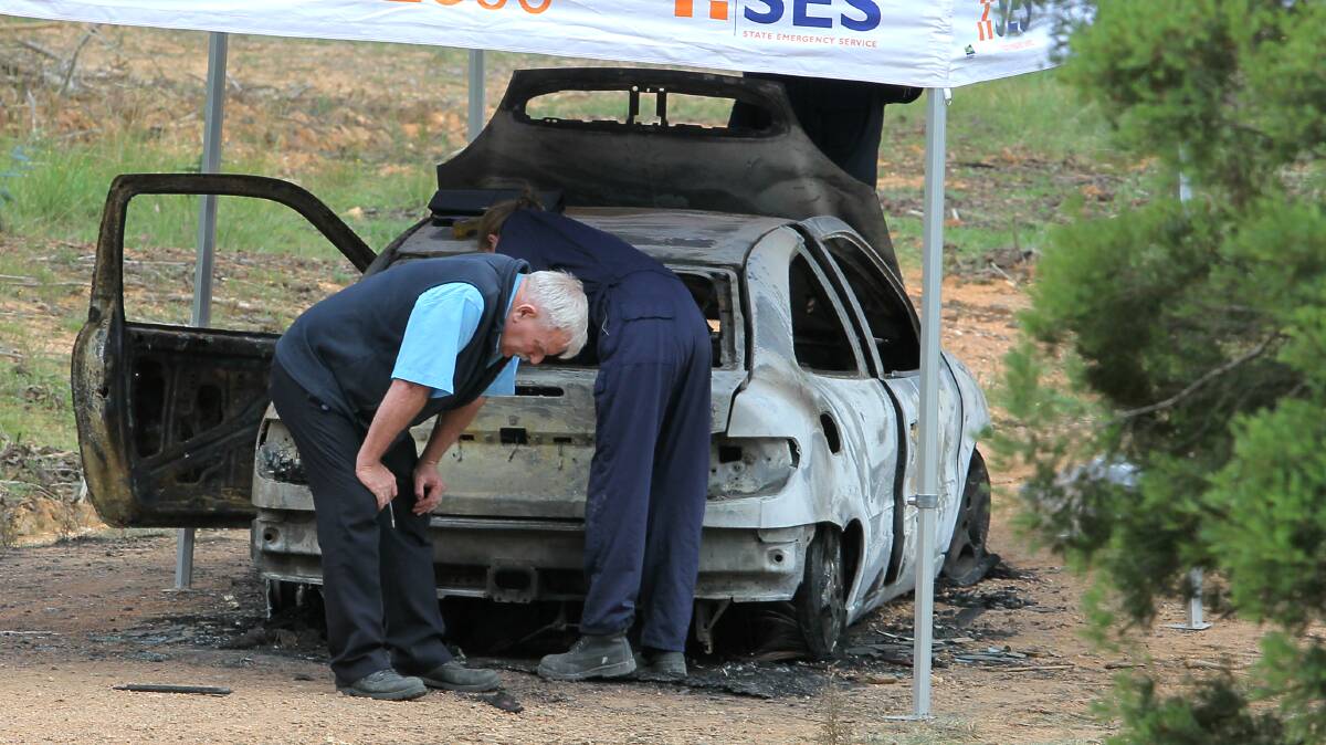 Investigators at the scene of the burnt-out car in Myrtleford. Police believe sightings of the car could provide them with vital information.