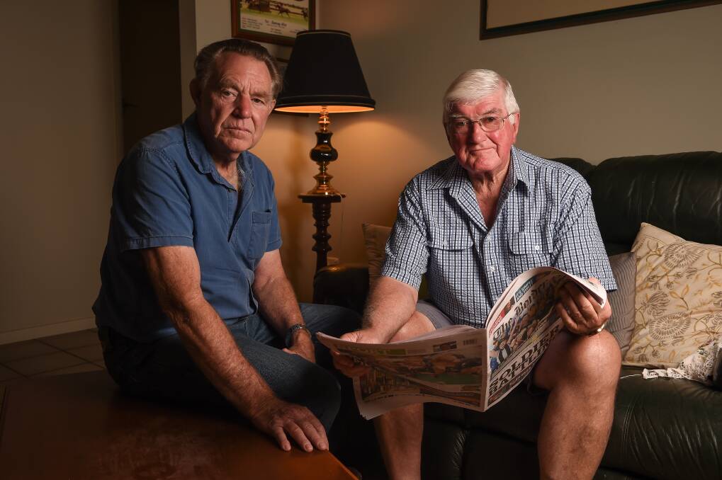 SHOCKED: Wodonga's Robert Thomson and Ian Page look through coverage of Tuesday's light plane crash in Melbourne. Picture: MARK JESSER