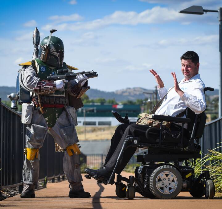 OUT OF THIS WORLD: Wodonga taxation clerical officer Scott Bishop in his Boba Fett costume, which took him over three years to hand-make, holds up Craig Parker of Albury on the Harold Mair bridge. Picture: MARK JESSER