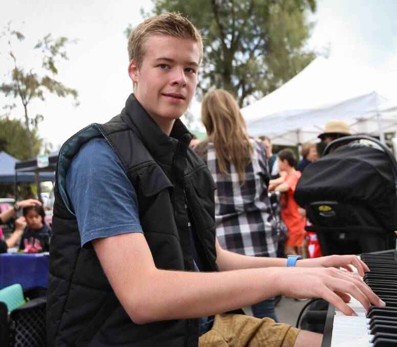 REGULAR: Jack Woodman, 15, behind the piano at the Gateway Village open day on Saturday, where he regularly busks to raise money for flying lessons. He hopes to hold a private pilot license at 17. Picture: JAMES WILTSHIRE