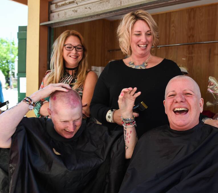 Hairdressers Lucy Tozer and Kristie Bright shave the heads of Chris Brine and Josie, raising money for the Turban Angels.