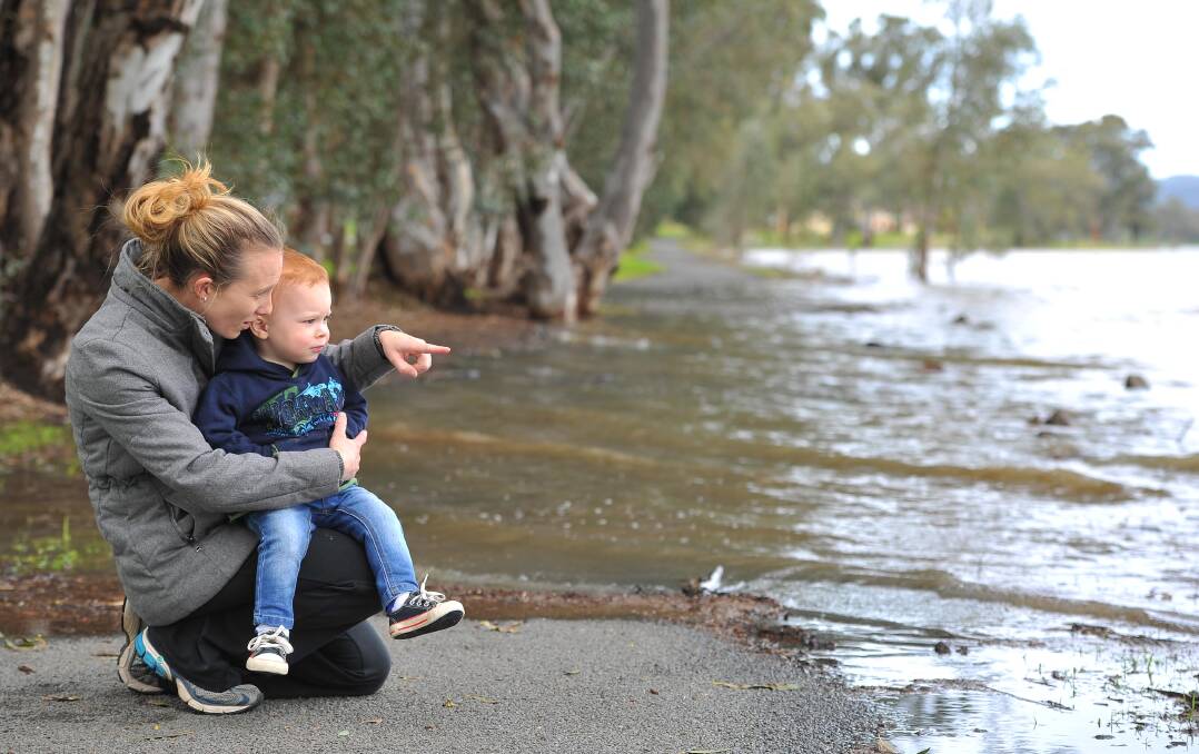WINTER DELUGE: Lisa Davies with son Jack, 2, marvel at the height of Lake Albert, which has burst its banks in places after the big wet. Picture: Kieren L Tilly