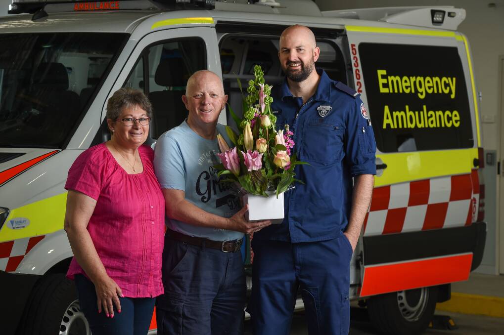 HAPPY ENDING: Lyn and Rob Groves with paramedic Shane Saunders, who performed CPR on Lyn en route to hospital. Picture: MARK JESSER
