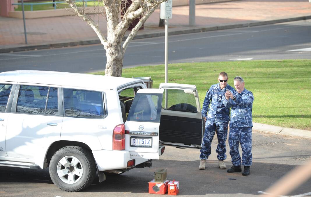 INACTIVE: Experts inspect the grenade on Thursday. Picture: Stephen Mudd.