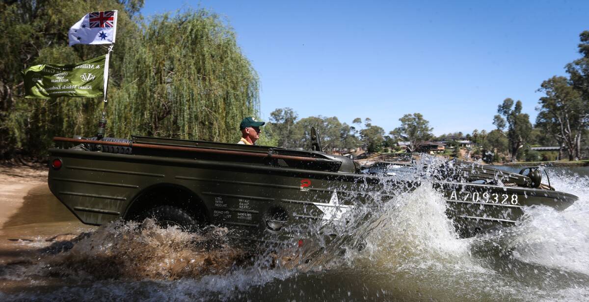 DRIVE AND DIVE: Manfred Hinkel goes full throttle into the Murray River in his aquatic jeep. Mr Hinkel changes to neutral and flicks a switch once in the water.
