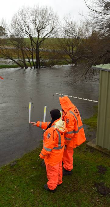 ON ALERT: SES volunteers keep tabs on the rising floodwaters in the Kiewa River near Tangambalanga on Monday. Picture: MARK JESSER