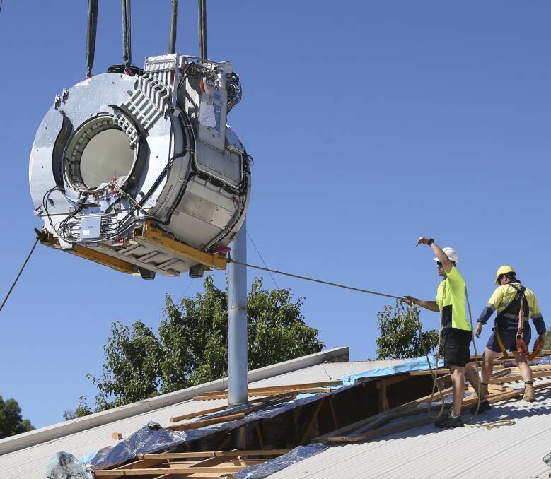 STEADY AS SHE GOES: A 5.5 tonne MRI scanner is eased into the roof of the Regional Imaging clinic in West Albury on Saturday by staff from Dunn's Twin City Cranes. Picture: SIMON BAYLISS