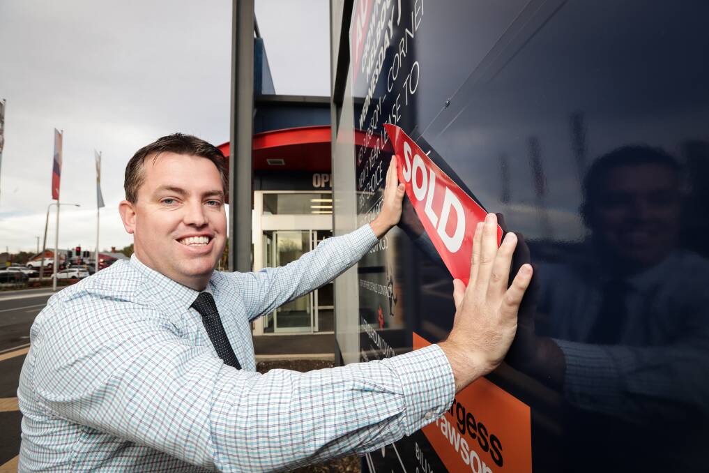 DONE DEAL: L.J. Colquhoun Dixon agent Bryce Livermore puts the sold sticker on the former Termo pub site in Albury after it sold for $6.6 million. Picture: JAMES WILTSHIRE