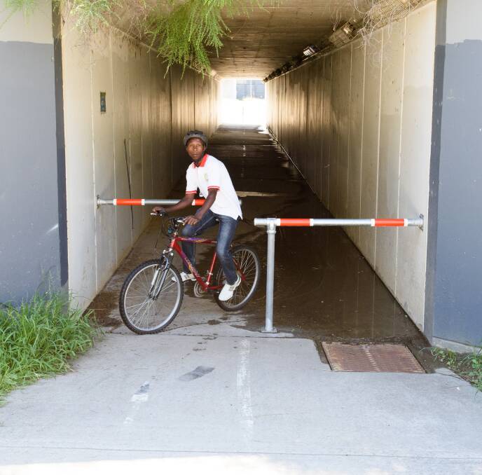 BE AWARE: Cyclist Amos Nizeyimana encounters new barriers erected at the entrance to an underpass near Union Road in Lavington. Picture: SIMON BAYLISS