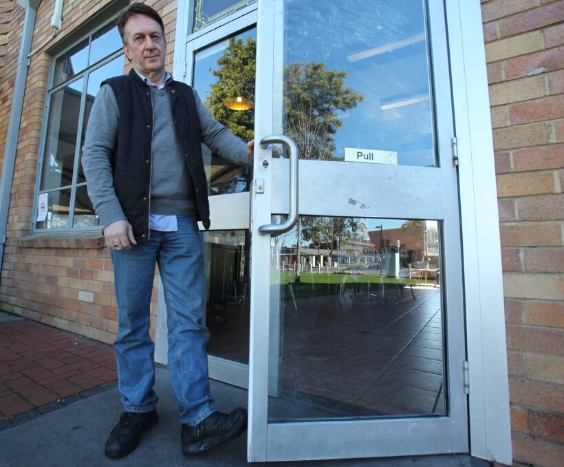 BRAZEN BREAK-IN: Trevor Broadbent says it was unnerving to discover a man had smashed a window and stolen from his business, Cafe Grove, on Monday night. He stands by the door which the thief used to escape.