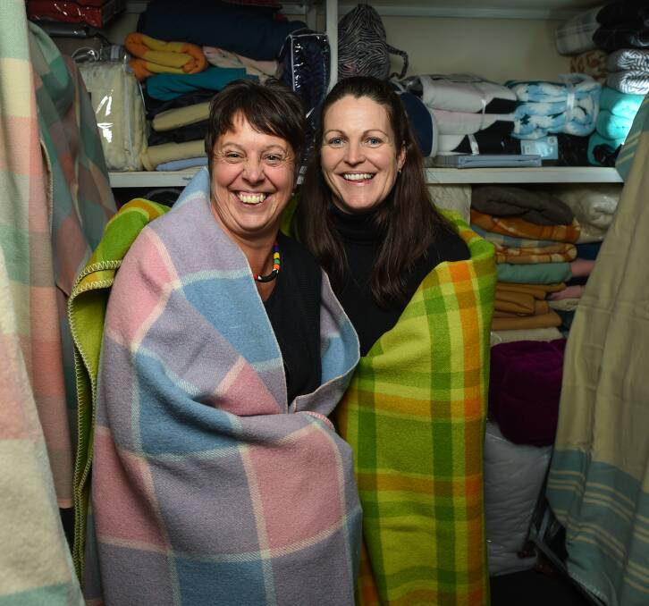 WARM FOR WINTER: Emergency relief co-ordinator Catherine Byrne and agency manager Naomi Jansen test out the goods. Picture: MARK JESSER