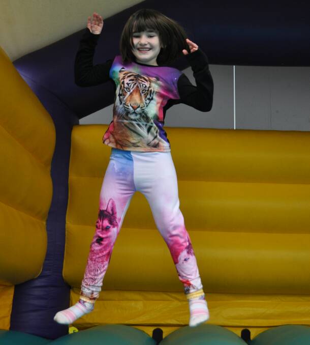 GIVING FIVE: Shania Treffers made a donation at the Give Me 5 For Kids fundraiser in Wodonga, before hopping on the jumping castle for some school holiday fun.