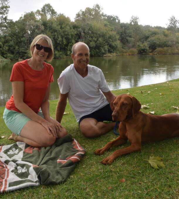 NOT FUSSED: Andrew and Sue Peake, with their dog Inca, relaxed by the water on Thursday to still make the most of Noreuil Park.