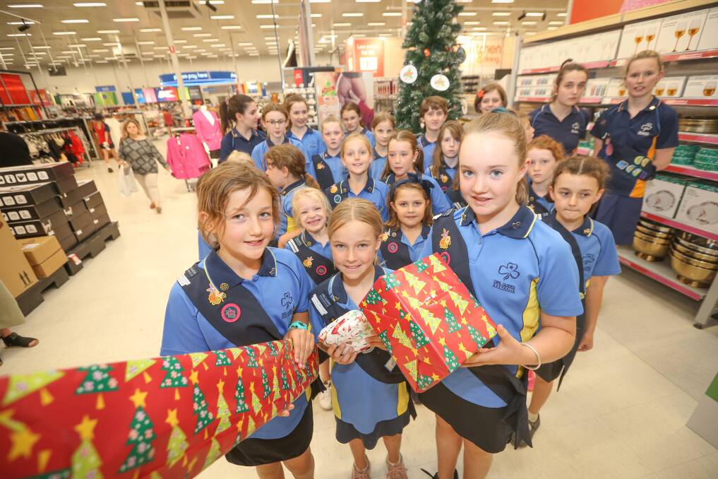 GIFT GIVING: Albury Girl Guides, including Georgia Ward, 10, Isabella Pope, 9, and Ruby Hilton, 10, chose a gift to put under the Kmart Wishing Tree. Picture: JAMES WILTSHIRE