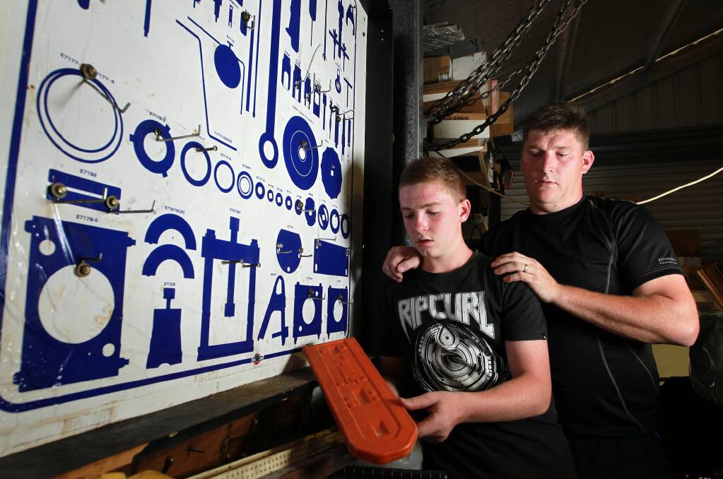 Lachlan Stoffels, 14, with his dad David next to the shadow board once covered in tools and the empty case. Picture: KYLIE ESLER